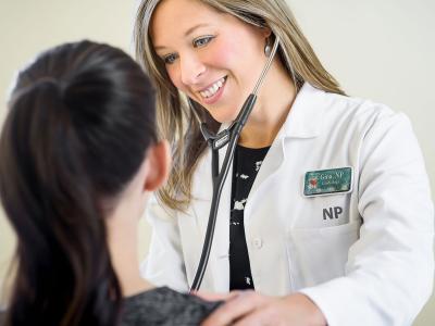 nurse practitioner checking heart of a patient 