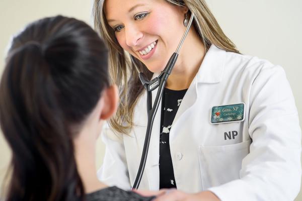 nurse practitioner checking heart of a patient 